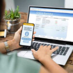 Person using online banking on laptop and smartphone.