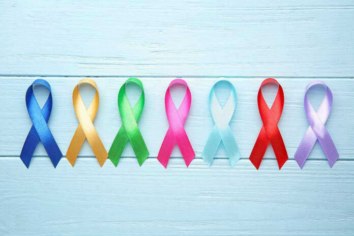 Colorful awareness ribbons on light wooden background