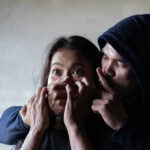 Democratic Hopeful’s Secret Victim-Blaming EXPOSED Man holding womans mouth, gesturing silence.