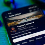 Tucker Carlson Tells Critics to “Buzz Off!” Smartphone displaying a YouTube channel profile page.