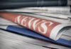 Stack of newspapers with NEWS headline visible.
