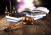 A gavel, legal books, and scales of justice on a wooden table
