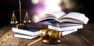 A gavel, legal books, and scales of justice on a wooden table