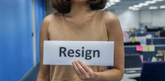 Person holding a sign that says resign