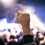 “You Killed Americans” Shout STUNS Chamber Raised fist in a crowd at night.