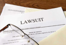 Documents labeled Lawsuit with glasses on top.