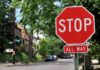A red stop sign with the words STOP and ALL WAY in a residential area