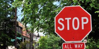 A red stop sign with the words STOP and ALL WAY in a residential area