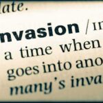 Close-up of a dictionary page showing the definition of the word invasion