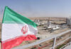 Iranian flag near an industrial gas refinery.