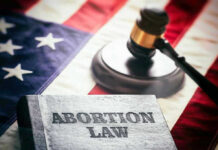 Abortion law book, gavel, and American flag.