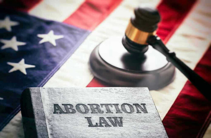 Abortion law book, gavel, and American flag.