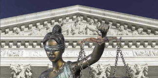 Lady Justice statue in front of courthouse.