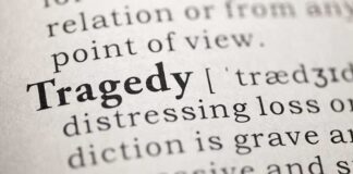 Close-up of the word 'Tragedy' in a dictionary with its definition