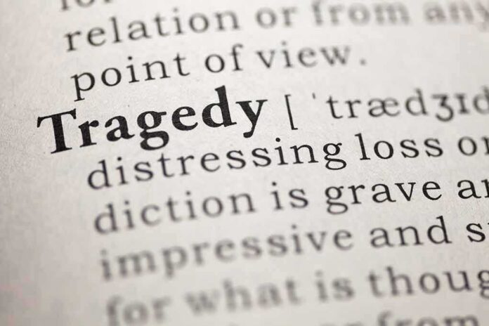 Close-up of the word 'Tragedy' in a dictionary with its definition
