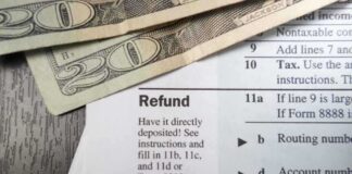 Close-up of tax refund form with cash on a wooden surface