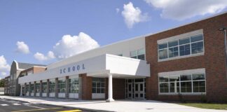 Modern school building with large windows and a clear sky