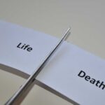Reality Star DEAD — Mysterious Speculation ABOUNDS Scissors cutting a paper strip labeled 'Life' and 'Death'