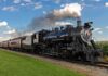 A vintage steam locomotive pulling passenger cars on a railway track