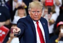 A speaker at a rally pointing towards the audience