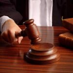 Court UNLEASHES HUGE Trump WIN! A judges hand holding a gavel over a wooden desk with law books