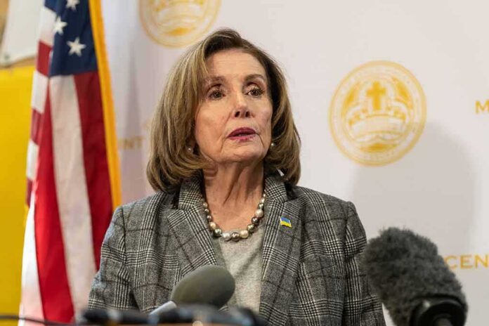 Nancy Pelosi speaking at a press conference with an American flag in the background