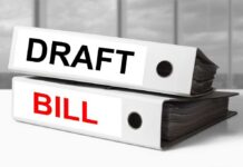 Two file folders labeled DRAFT and BILL stacked on a desk