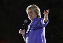 A woman speaking into a microphone at an outdoor event