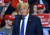 Person at a rally with Make America Great Again signs.