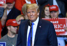 Trump’s UNEXPECTED SHOWDOWN: Loyalty Over Legacy Person at a rally with Make America Great Again signs.