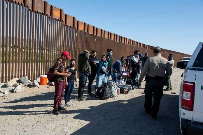 1973414822-2 Border patrol agents interact with a group of people.