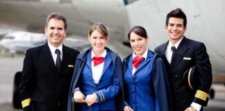 Group of airline crew members posing together at an airport