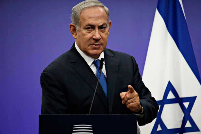 1042782061 Man in suit giving speech in front of Israeli flag.