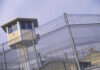 White House Says Killed in Sea Strike, Details Unverified Guard tower behind barbed wire fence in a prison.
