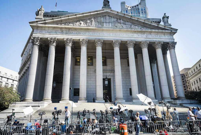 2445868619-1 Courthouse facade with media crews setting up outside.
