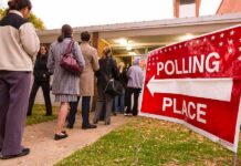 Vegan Push Criminalizes Dinner People waiting in line at a polling place with a sign indicating direction