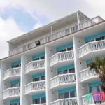 €4B Albania Resort Sparks Protests and Corruption Probe Exterior view of a beachfront hotel with balconies and colorful towels hanging