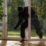 Break-In Turns Deadly in Oklahoma A burglar in dark clothing entering a house through a glass door