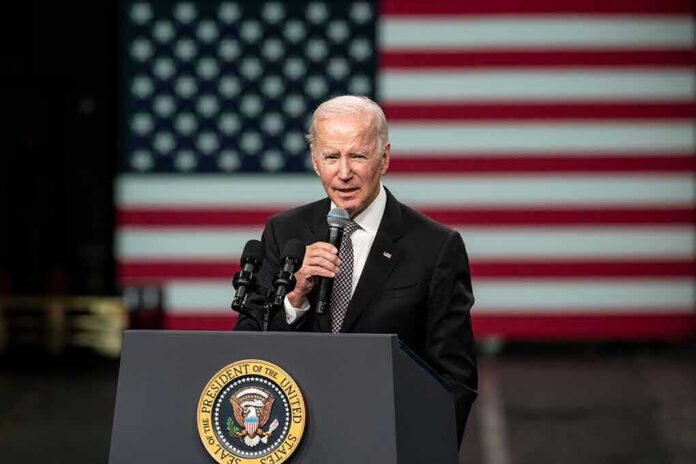2210954843 Man speaking at podium with US flag background.