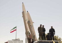 One Word Divides the Debate: ‘Obliterated.’ Military personnel beside missiles and Iranian flag.