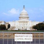 Autopsy Twist Shakes Washington View of the U.S. Capitol building with a security barrier in front