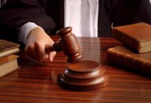 Court Draws the Line: Girls’ Sports Reserved for Biological Females A judges hand holding a gavel over a wooden desk with law books