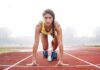 Female sprinter in starting blocks on a track
