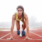 Female sprinter in starting blocks on a track