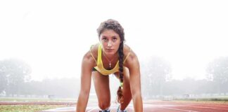 Female sprinter in starting blocks on a track