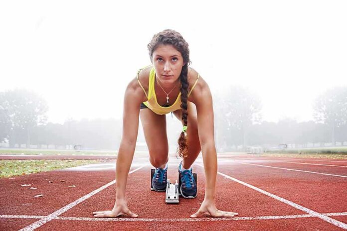 Female sprinter in starting blocks on a track
