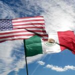 United States and Mexico flags waving against a bright sky