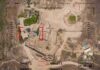 Aerial view through drone HUD of archaeological ruins and surrounding campsite