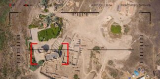 Aerial view through drone HUD of archaeological ruins and surrounding campsite