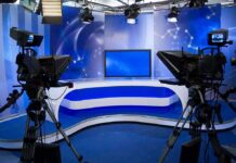After Prison and a Presidential Commutation A television studio setup with cameras and a blue backdrop